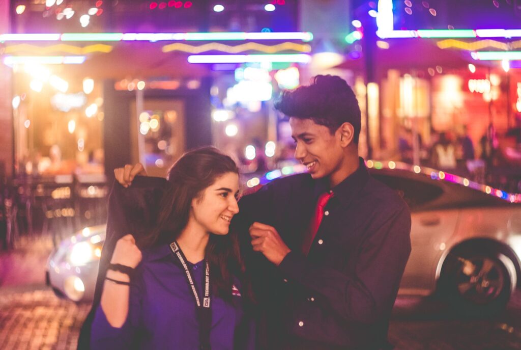 man giving jacket to woman